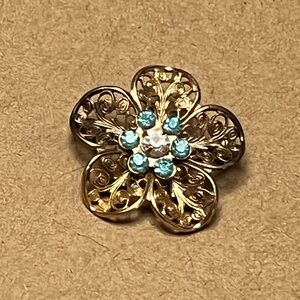 Vintage lacy gold tone flower pin brooch with blue rhinestones